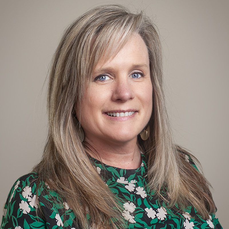 Image of Burkett CPAs Vice President Allison Ford, smiling, wearing a floral patterned garment