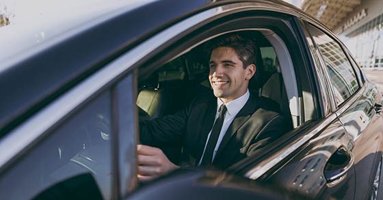 smiling businessman driving a car