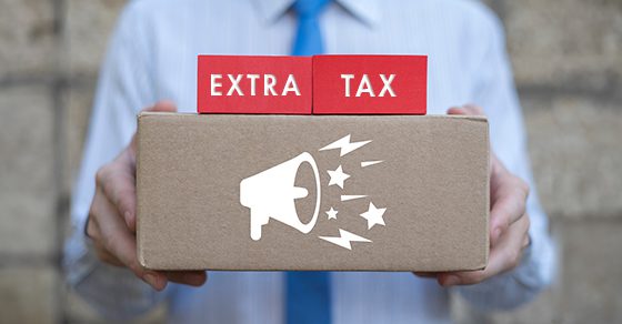 person in business attire holding cardboard box with words "Extra Tax" above it